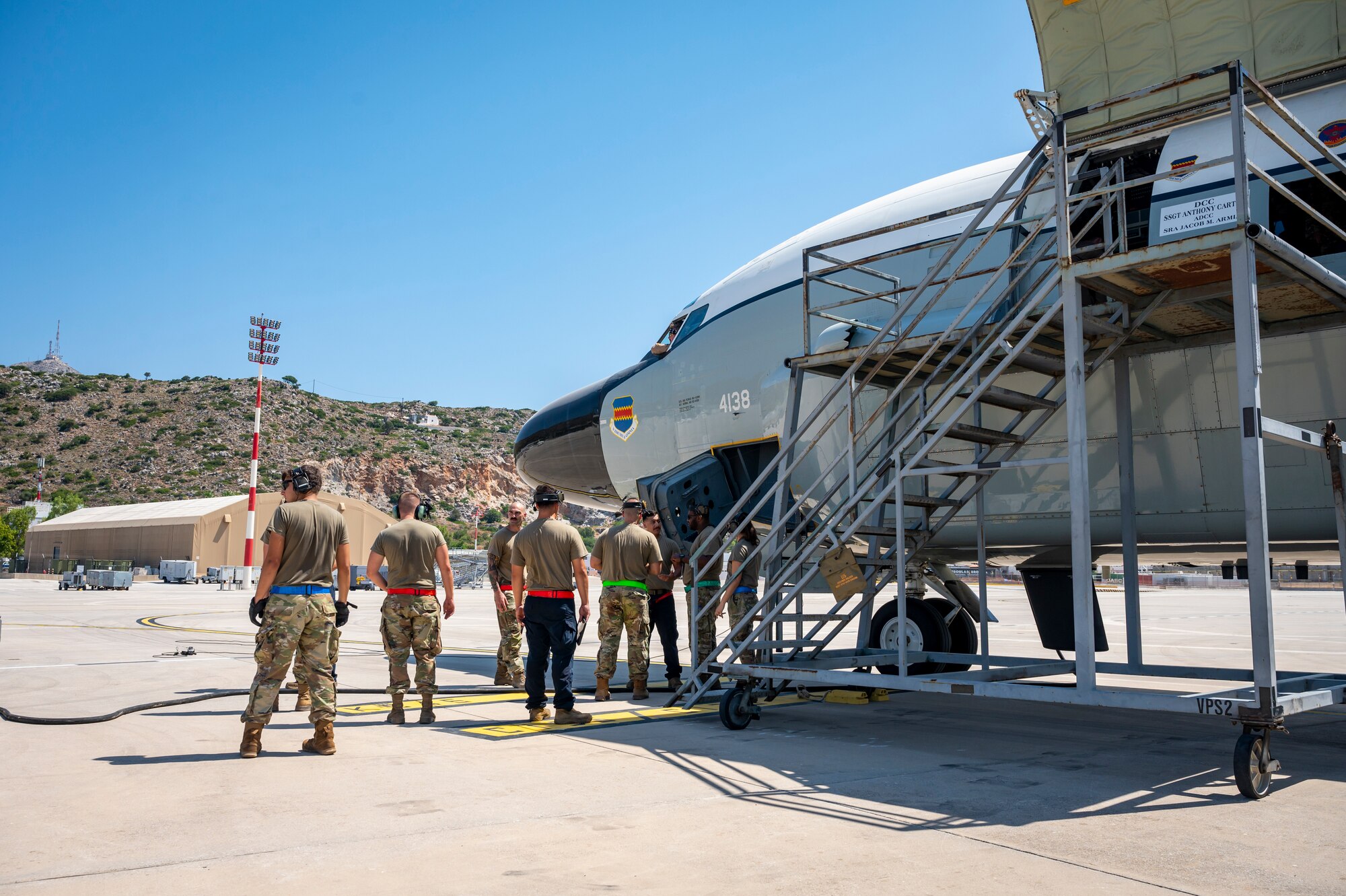 Service members next to a parked aircraft