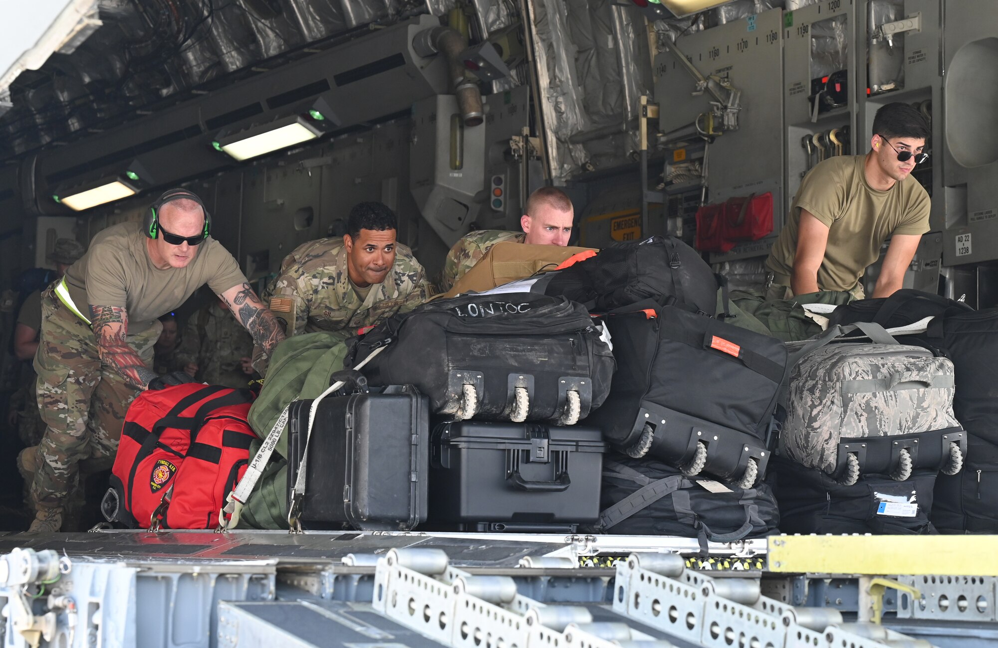 A photo of four Airmen pushing a pallet.