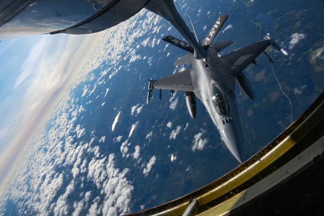 An F-16 Fighting Falcon receives air-to-air refueling from a KC-135 Stratotanker.