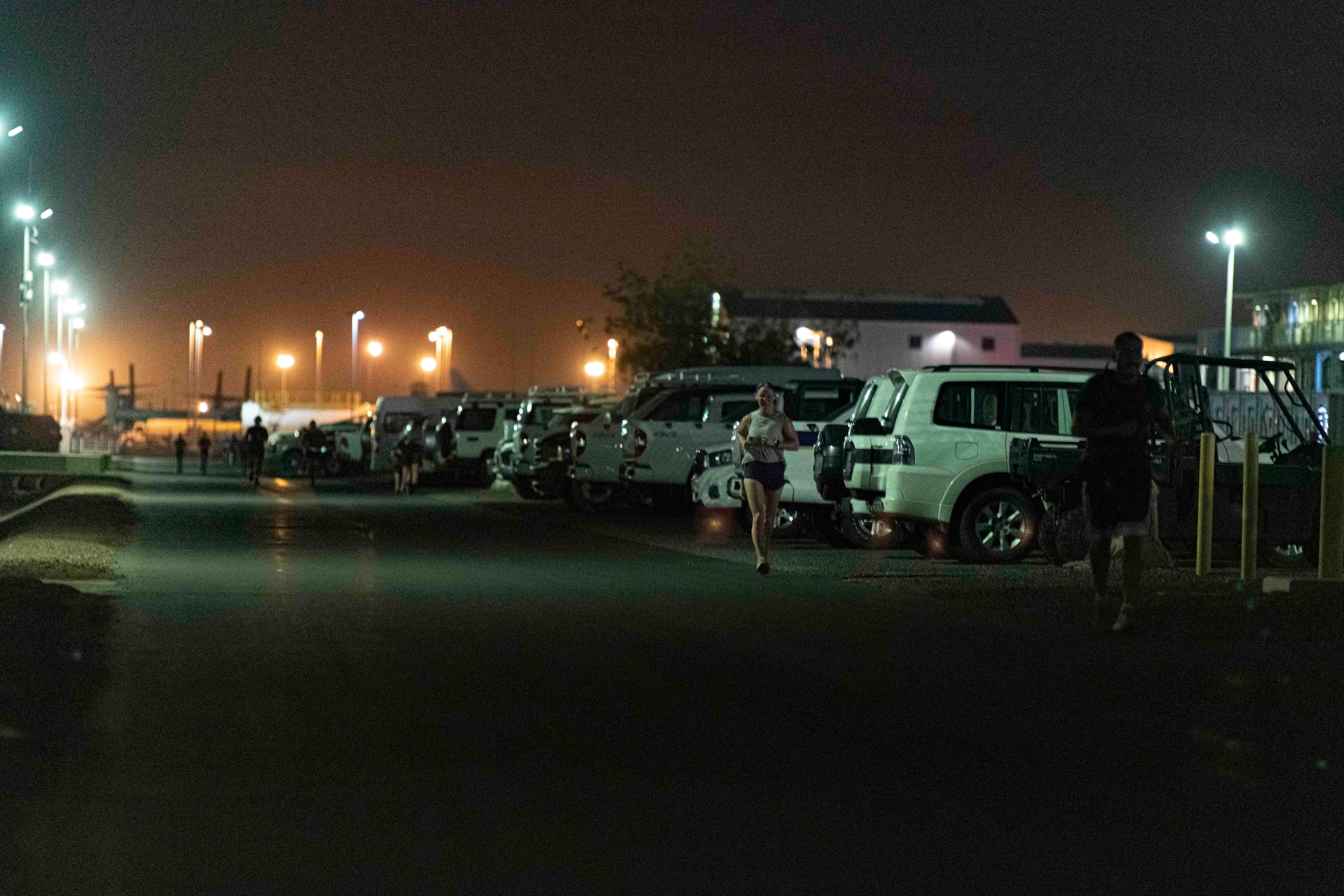 Photo of runners running on a road at night