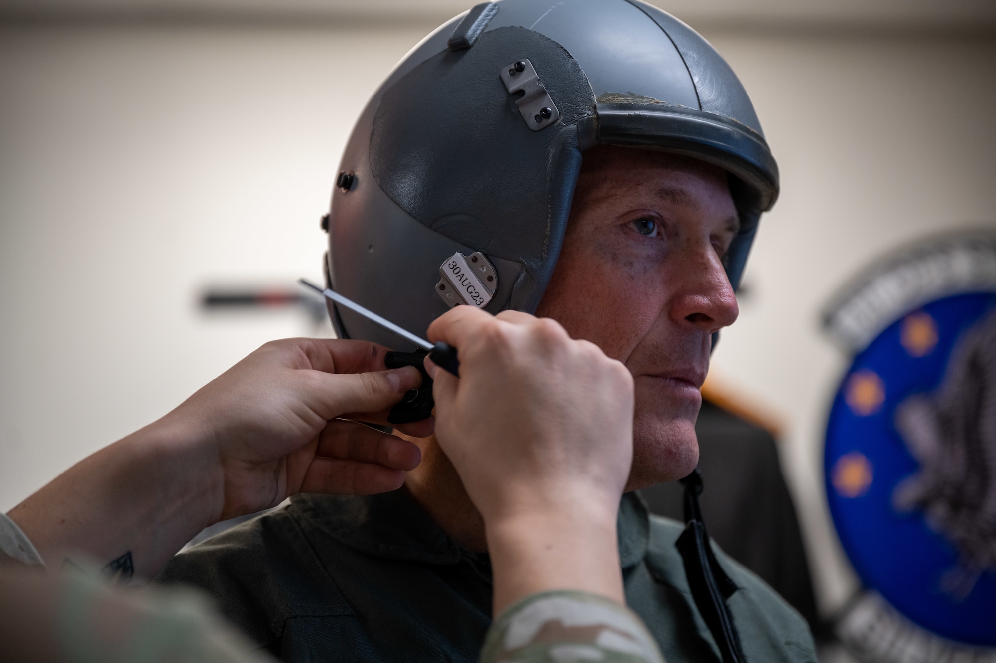 Ted Budd, center, North Carolina Senator, gets fitted for a flight helmet during a visit at Seymour Johnson Air Force Base, North Carolina, Aug. 18, 2023. While Budd visited he was fitted for flight equipment, received a flight physical and participated in an F-15E Strike Eagle incentive flight. (U.S. Air Force photo by Senior Airman David Lynn)