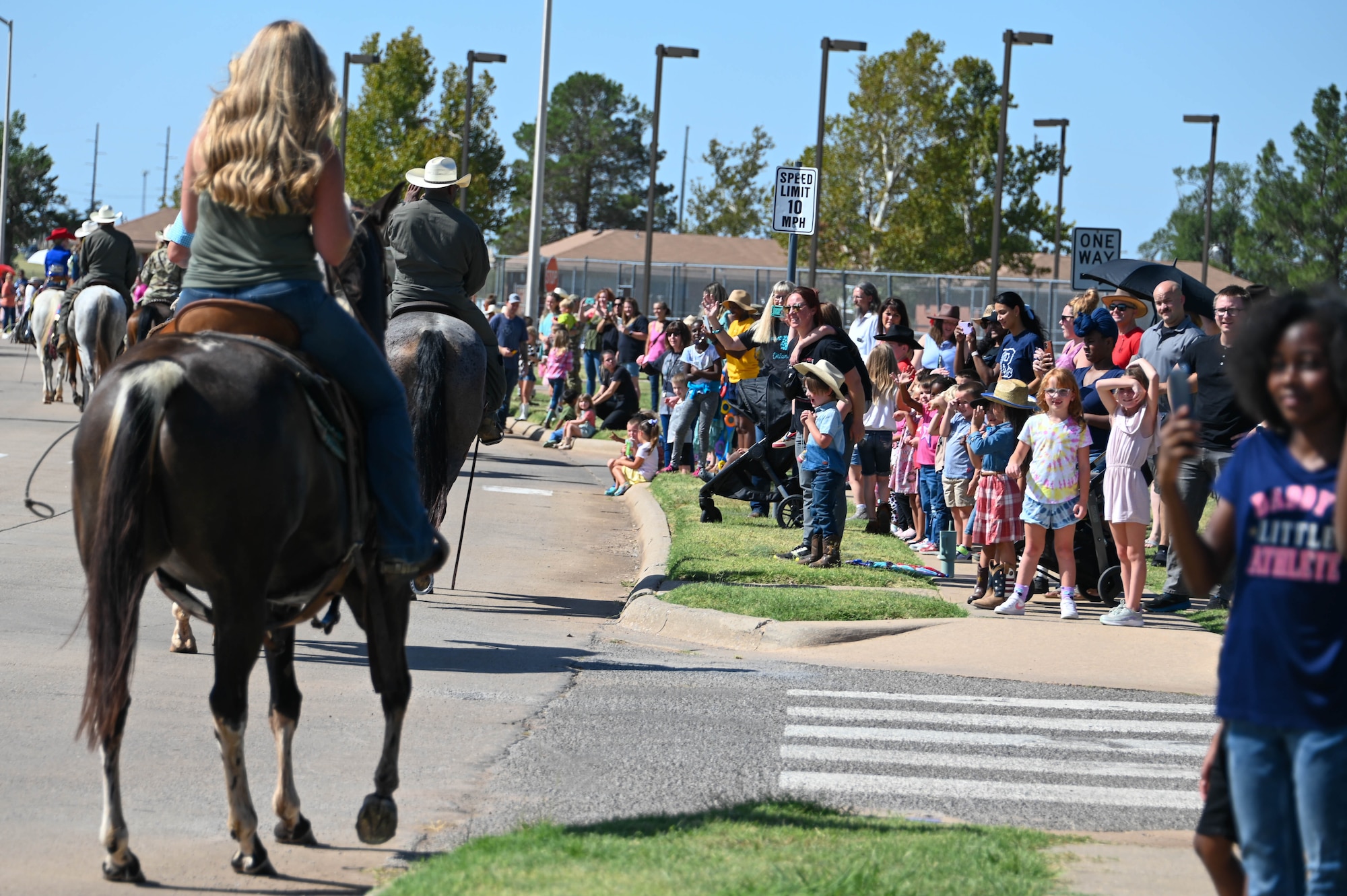 Children from L. Mendel Rivers Elementary School observe 97th Air Mobility Wing leaders and local ranchers ride horses during the 25th annual Cattle Drive at Altus Air Force Base, Oklahoma, Aug. 24, 2023. The kids were able to pet horses and meet with members running the cattle drive. (U.S. Air Force photo by Airman 1st Class Heidi Bucins)