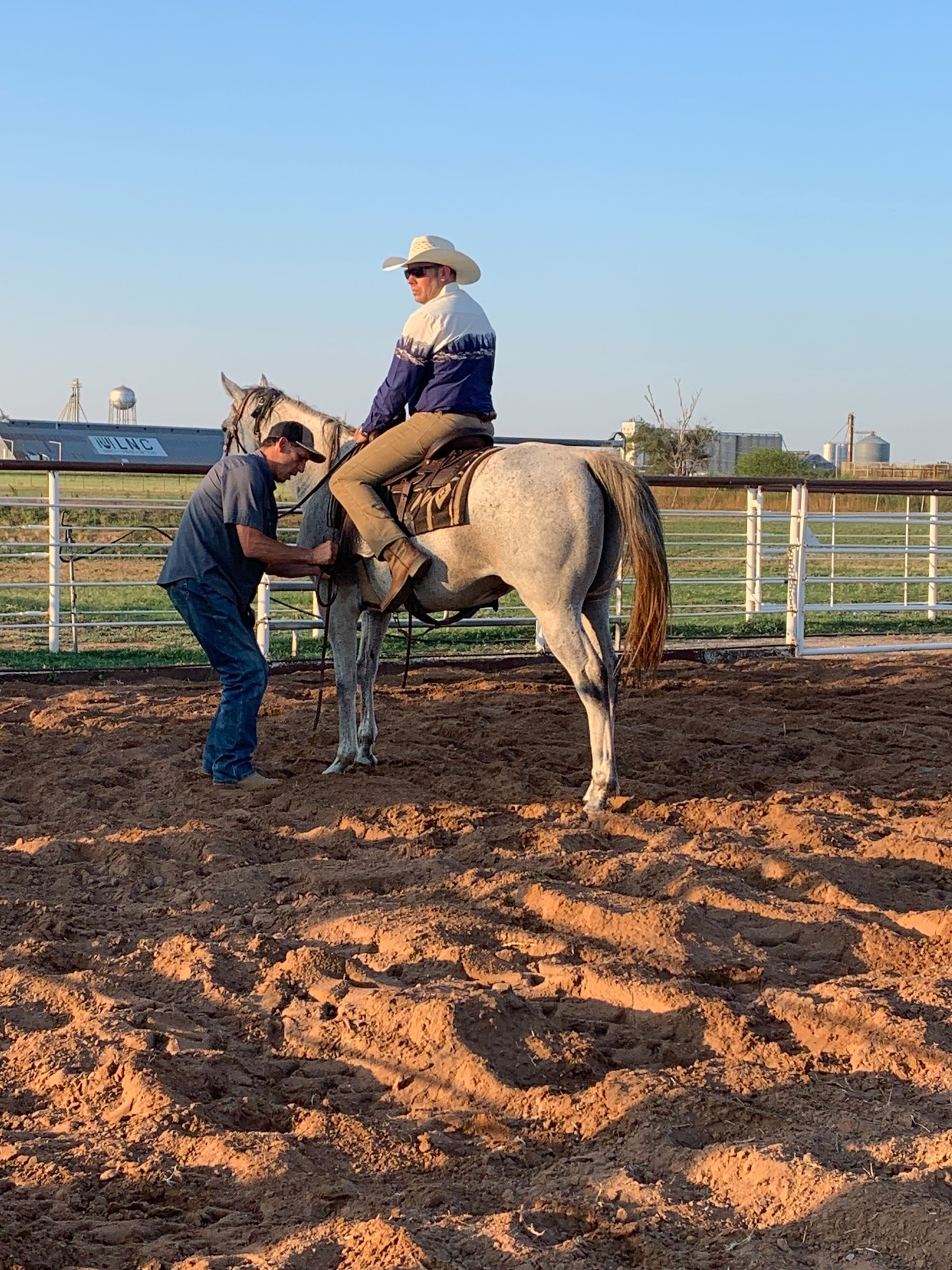 U.S. Air Force Chief Master Sgt. Justin Brundage, 97th Air Mobility Wing command chief, gets his saddle adjusted during a saddle fitting for the 25th Annual Cattle Drive in Altus, Oklahoma, Aug. 19, 2023. Wing leaders and community members guided cattle around Altus Air Force Base on horseback as part of an annual tradition. (U.S. Air Force photo by Airman 1st Class Kari Degraffenreed)