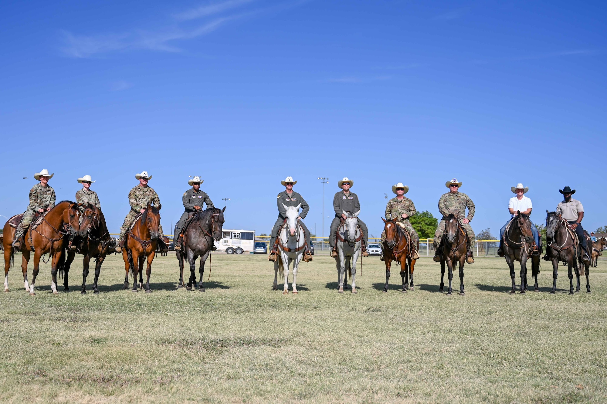 Leaders from the 97th Air Mobility Wing pose for a photo during the 25th Annual Cattle Drive at Altus Air Force Base (AFB), Oklahoma, Aug. 24, 2023. The command team, group commanders and command chiefs rode alongside local ranchers and dozens of longhorn cattle throughout Altus AFB. (U.S. Air Force photo by Airman 1st Class Kari Degraffenreed)