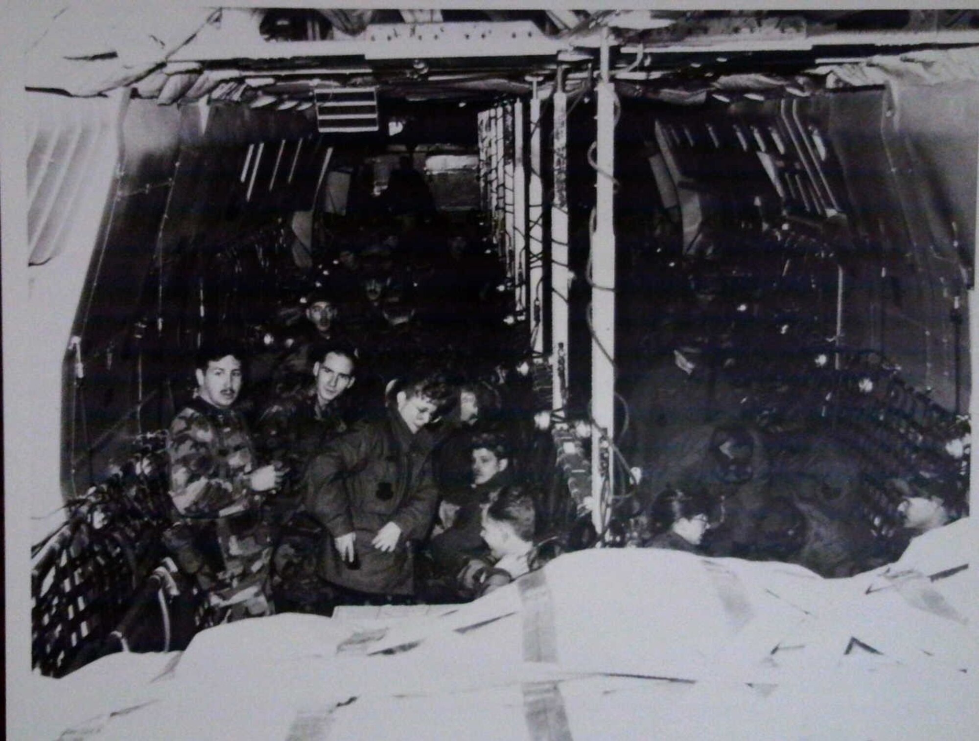 Military members board a plane in a historic photo.