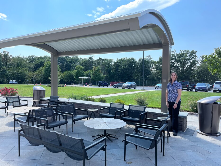 Woman standing outside under a shade.