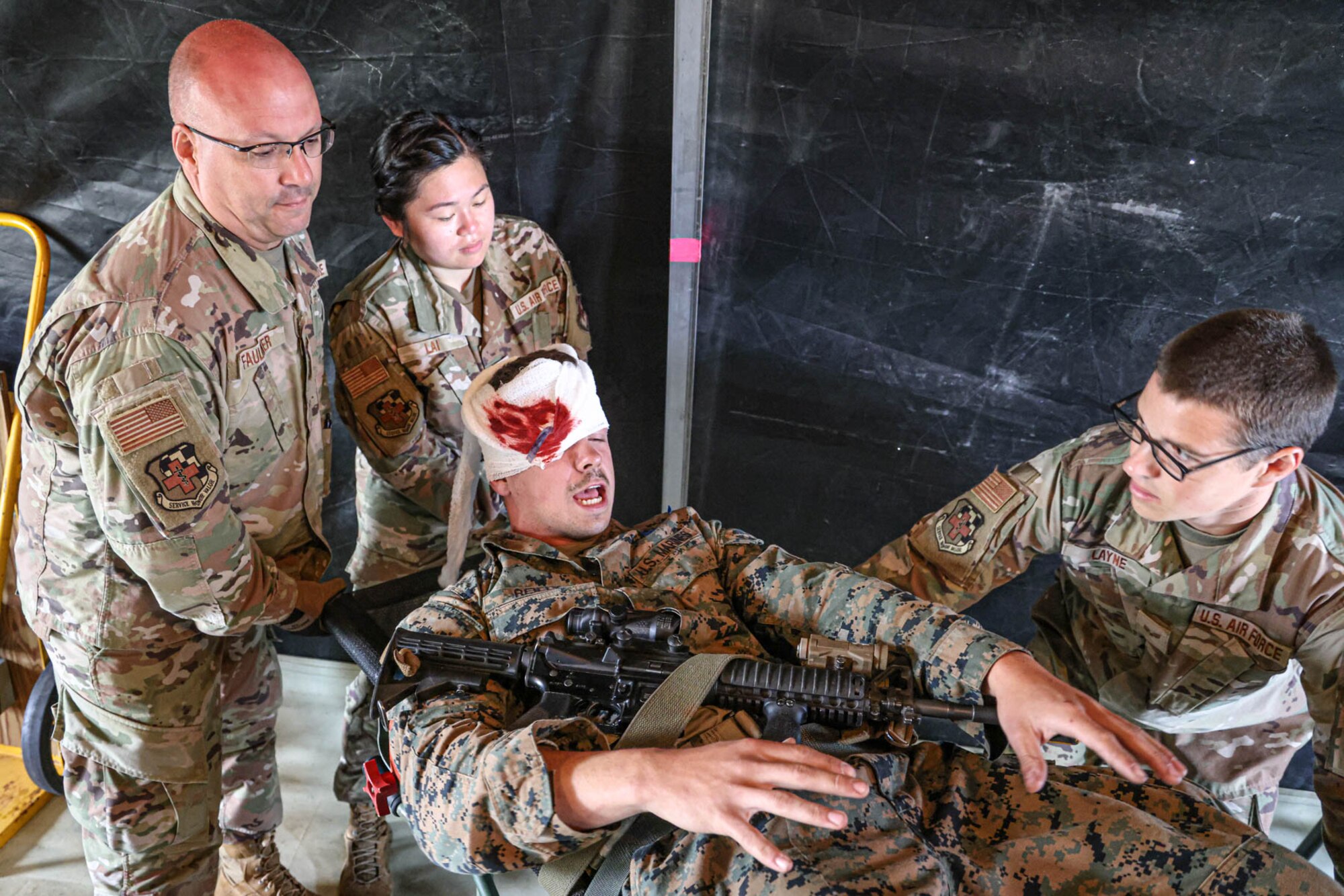 U.S. Air Force Master Sgt. Brian Faulkner, left, Staff Sgt. Kimberly Lai, center, and Senior Airman Cameron Layne, right, all aerospace medical technicians with the Michigan National Guard’s 127th Medical Group, simulate transporting patients for evacuation during an Exercise Northern Strike 23 joint medical training event at the Grayling Army Air Field, Grayling, Michigan, Aug. 15, 2023. NS23 is one of the National Guard’s largest annual joint, readiness-producing exercises, held within the Michigan National Guard’s, “National All-Domain Warfighting Center,” and designed to challenge the training audience in a variety many ways, including contested sustainment/logistics. (U.S. Air National Guard photo by Tech. Sgt. Andrew Schumann