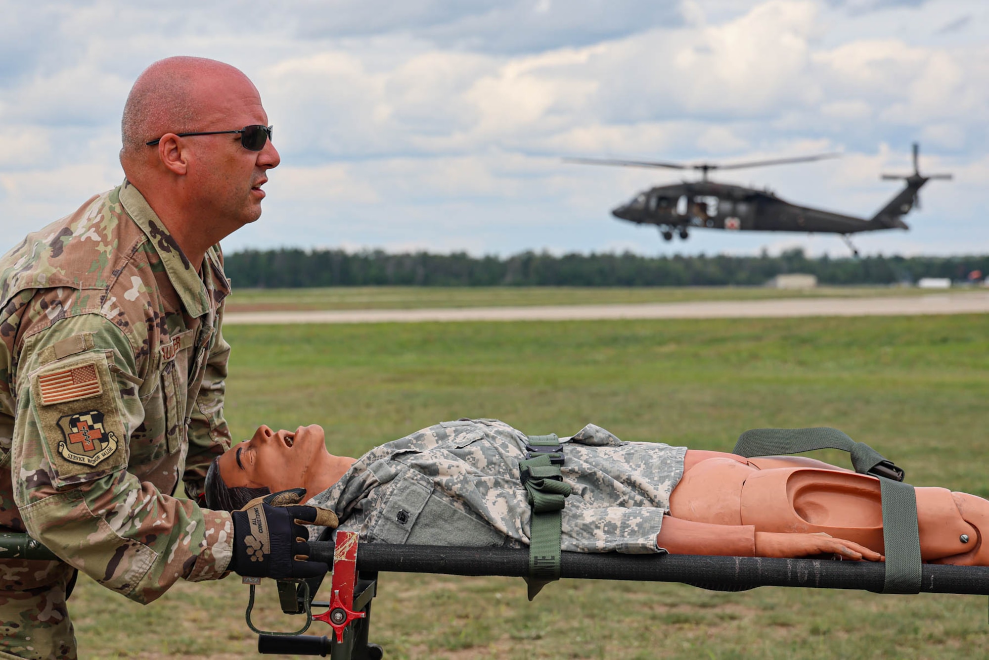 U.S. Air Force Master Sgt. Brian Faulkner, an aerospace medical technician from the Michigan National Guard’s 127th Medical Group, simulates patient evacuation during an Exercise Northern Strike 23 joint medical training event at the Grayling Army Air Field, Grayling, Michigan, Aug. 14, 2023. NS23 is a premier reserve component training event that integrates both U.S. and partner nation readiness training to build interoperability and strengthen partnerships in an all-domain environment. (U.S. Air National Guard photo by Tech. Sgt. Andrew Schumann)