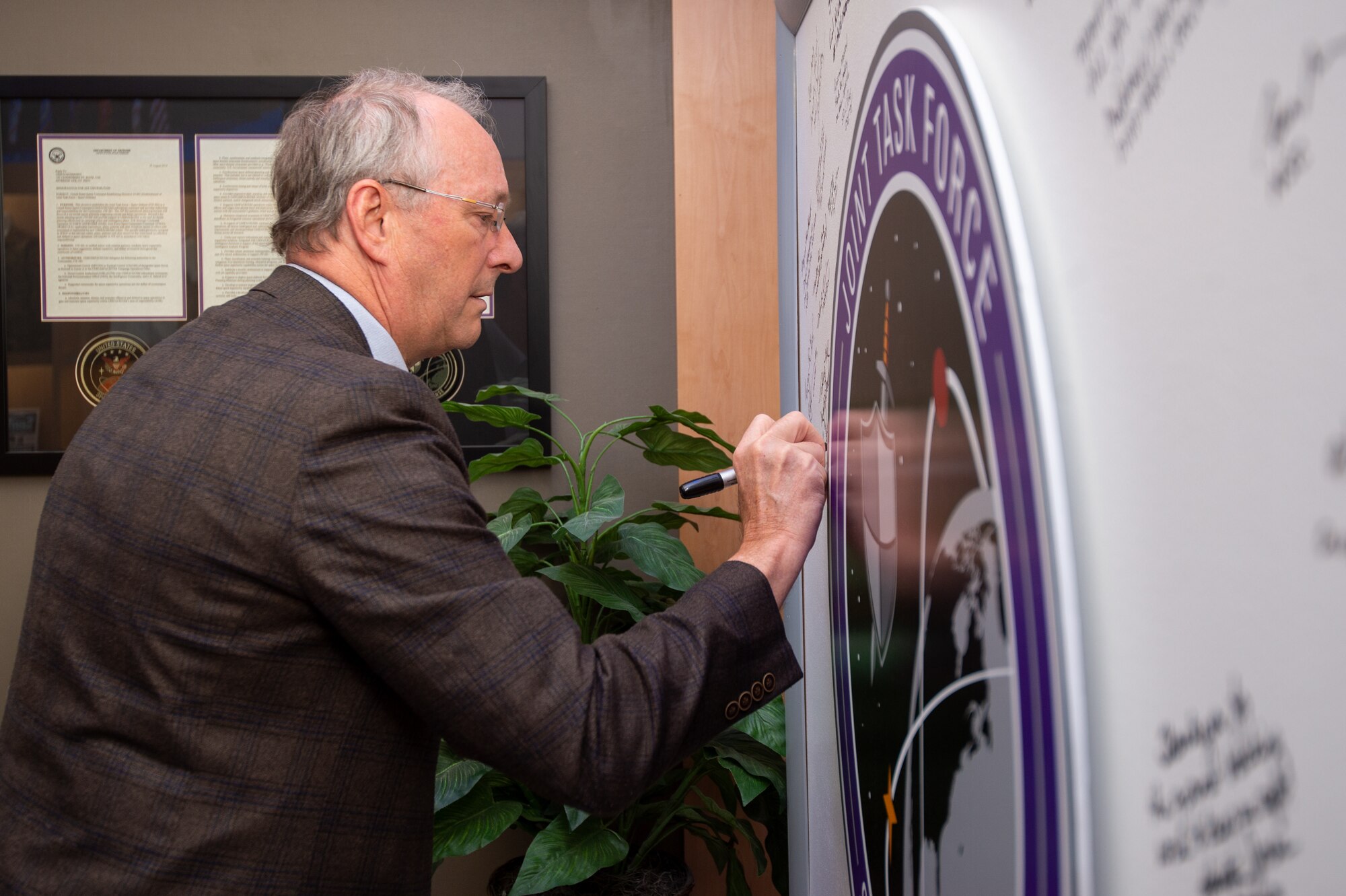 Man in suit signing white board