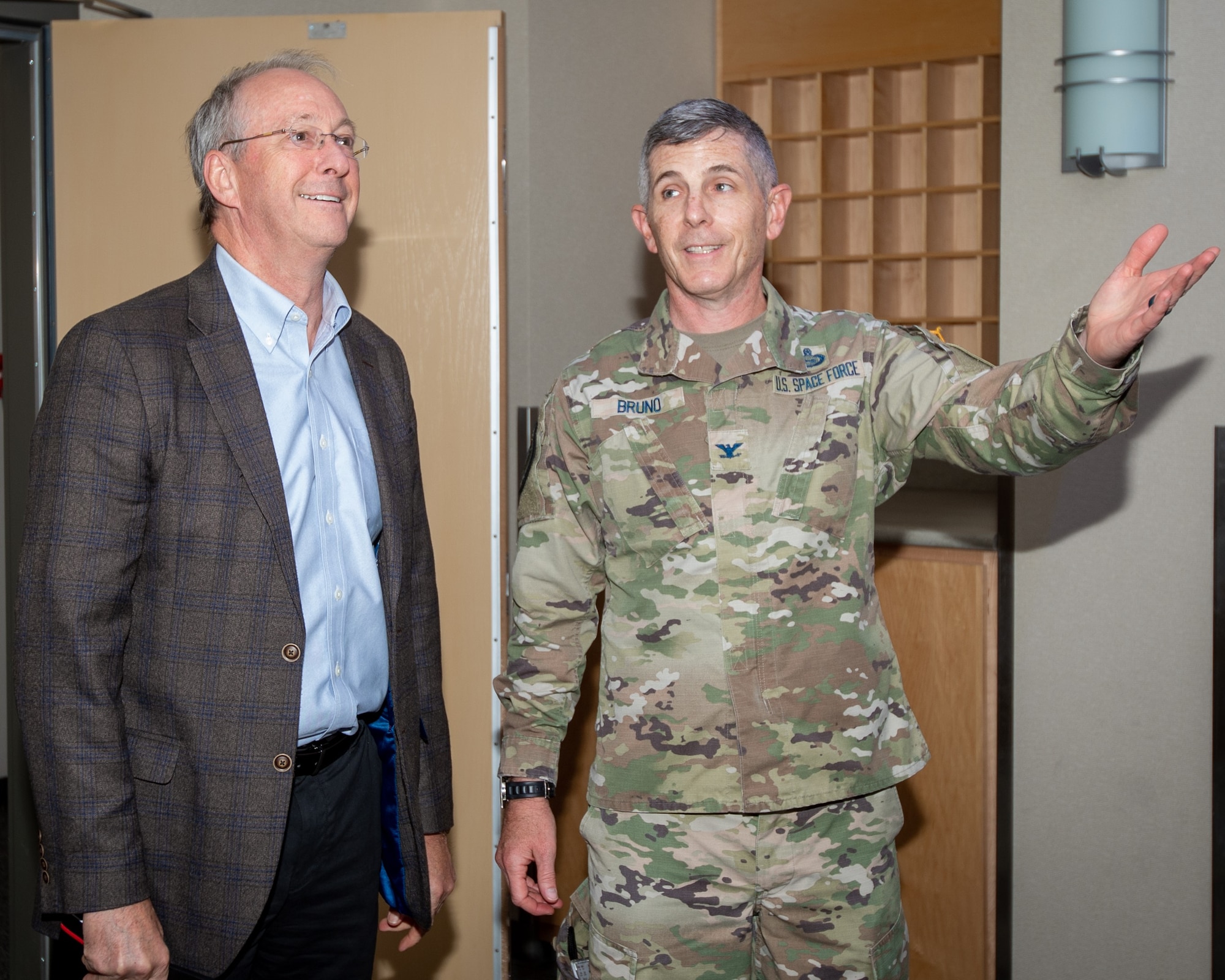 Man in suit talks to man in military uniform