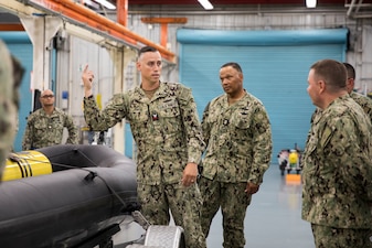 Sonar Technician (Submarine) 1st Class Joshua Smith briefs Personnel, Manpower, and Training Fleet Master Chief Delbert Terrell Jr. Delbert Terrell Jr. and Chief of Naval Personnel Vice Adm. Rick Cheeseman about an unmanned undersea vehicle inside the Unmanned Undersea Vehicle Squadron 1 (UUVRON-1) facility