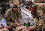 Aeromedical evacuation technicians from the 183rd Aeromedical Evacuation Squadron administer aid to a simulated patient during medical airlift evacuation training in Gulfport, Mississippi, July 20, 2023. The 183rd Aeromedical Evacuation Squadron conducted annual training with the 189th Medical Group, Arkansas ANG, U.S. Coast Guard New Orleans and Gulfport.