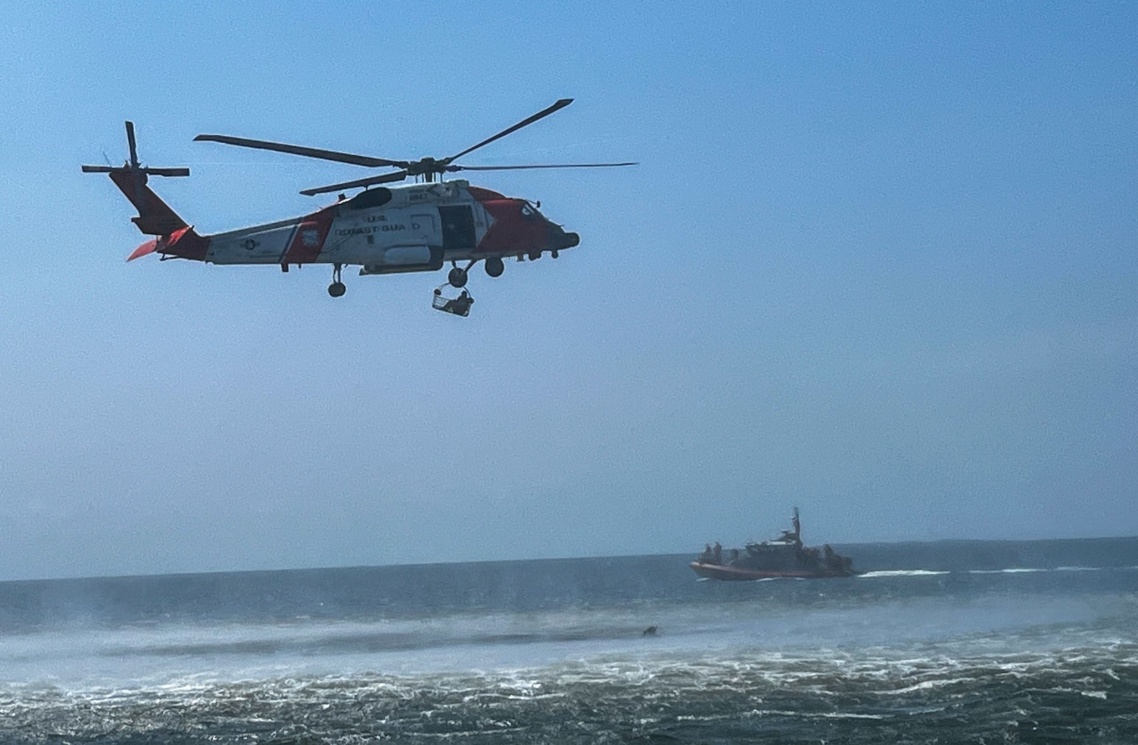 U.S. Coast Guardsmen from U.S. Coast Guard Station New Orleans hoist an Airman from the water to an MH-60 Jayhawk during a simulated search and rescue mission in Gulfport, Mississippi, July 19, 2023. The 183rd Aeromedical Evacuation Squadron conducted annual training with the 189th Medical Group, Arkansas ANG, and U.S. Coast Guardsmen from Gulfport and New Orleans.