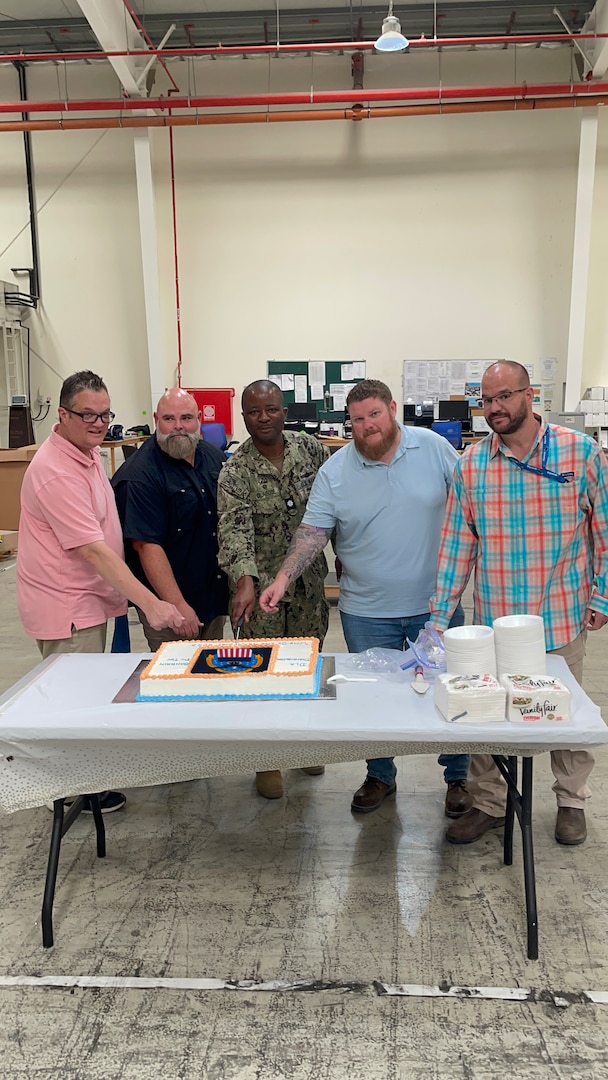 five people cutting into a cake