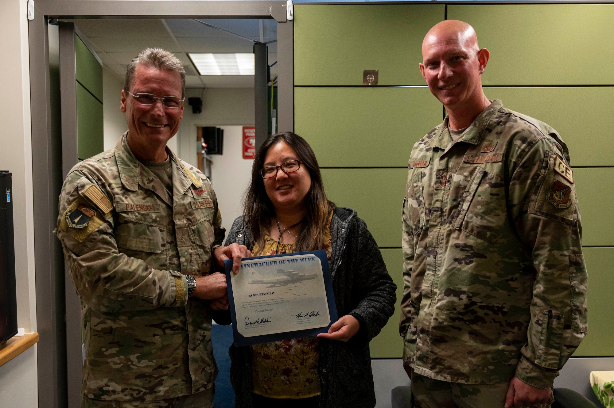 Kourtney Eay, a budget analyst with the 36th Comptroller Squadron, receives the Linebacker of the Week Award from U.S. Air Force Brig. Gen. Paul Fast, commander of the 36th Wing, and U.S. Air Force Chief Master Sgt. Donald McNair, the senior enlisted leader of the 36th Civil Engineering Squadron, at Andersen Air Force Base, Guam, Aug. 23, 2023. The Team Andersen Linebacker of the Week recognizes outstanding enlisted, officer, civilian and total force personnel who have had an impact on achieving Team Andersen’s mission, vision and priorities. (U.S. Air Force photo by Airman 1st Class Emily Saxton)