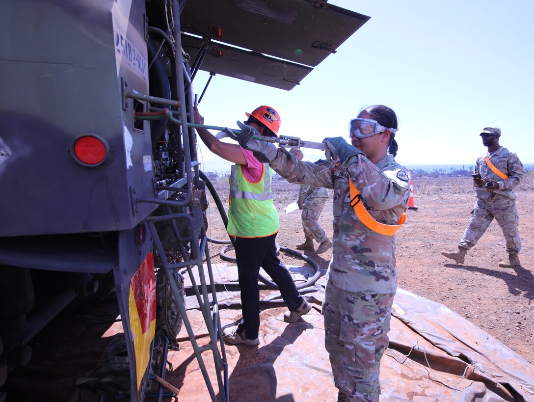 Spc. Abraham Arreortua, petroleum supply specialist, from 25th Infantry Division, deploys a fuel line at the forward fuel supply point on Maui, Aug. 23. The 25th ID Soldiers are using a Heavy Expandable Mobile Tactical Truck at a forward fuel point to optimize refueling efficiency for USACE contractors who pick up and deliver fuel to 20 Federal Emergency Management Agency generators installed at critical facilities that lost power following the wildfires Aug. 8.