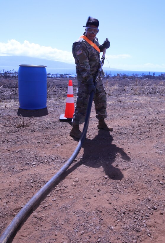 Spc. Abraham Arreortua, petroleum supply specialist, from 25th Infantry Division, deploys a fuel line at the forward fuel supply point on Maui, Aug. 23. The 25th ID Soldiers are using a Heavy Expandable Mobile Tactical Truck at a forward fuel point to optimize refueling efficiency for USACE contractors who pick up and deliver fuel to 20 Federal Emergency Management Agency generators installed at critical facilities that lost power following the wildfires Aug. 8.