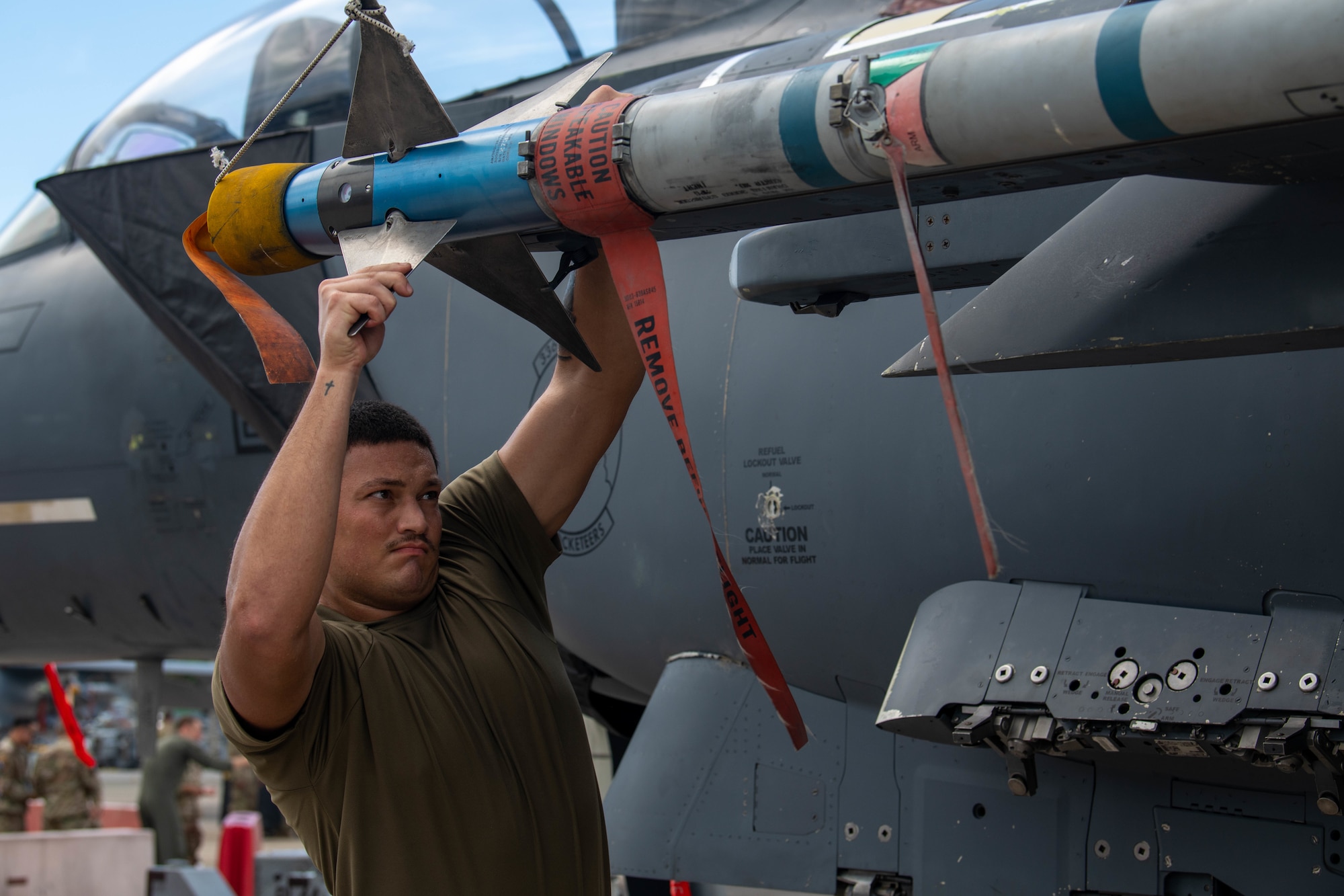 Technician loads weaponry onto an F-15E Strike Eagle during a weapons load competition.