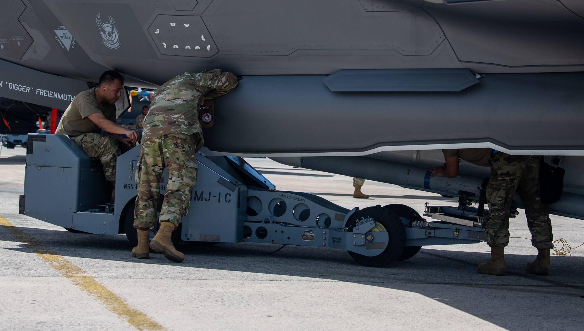 Weapons load crew members load weaponry onto an F-35A Lightning II during a weapons load competition.