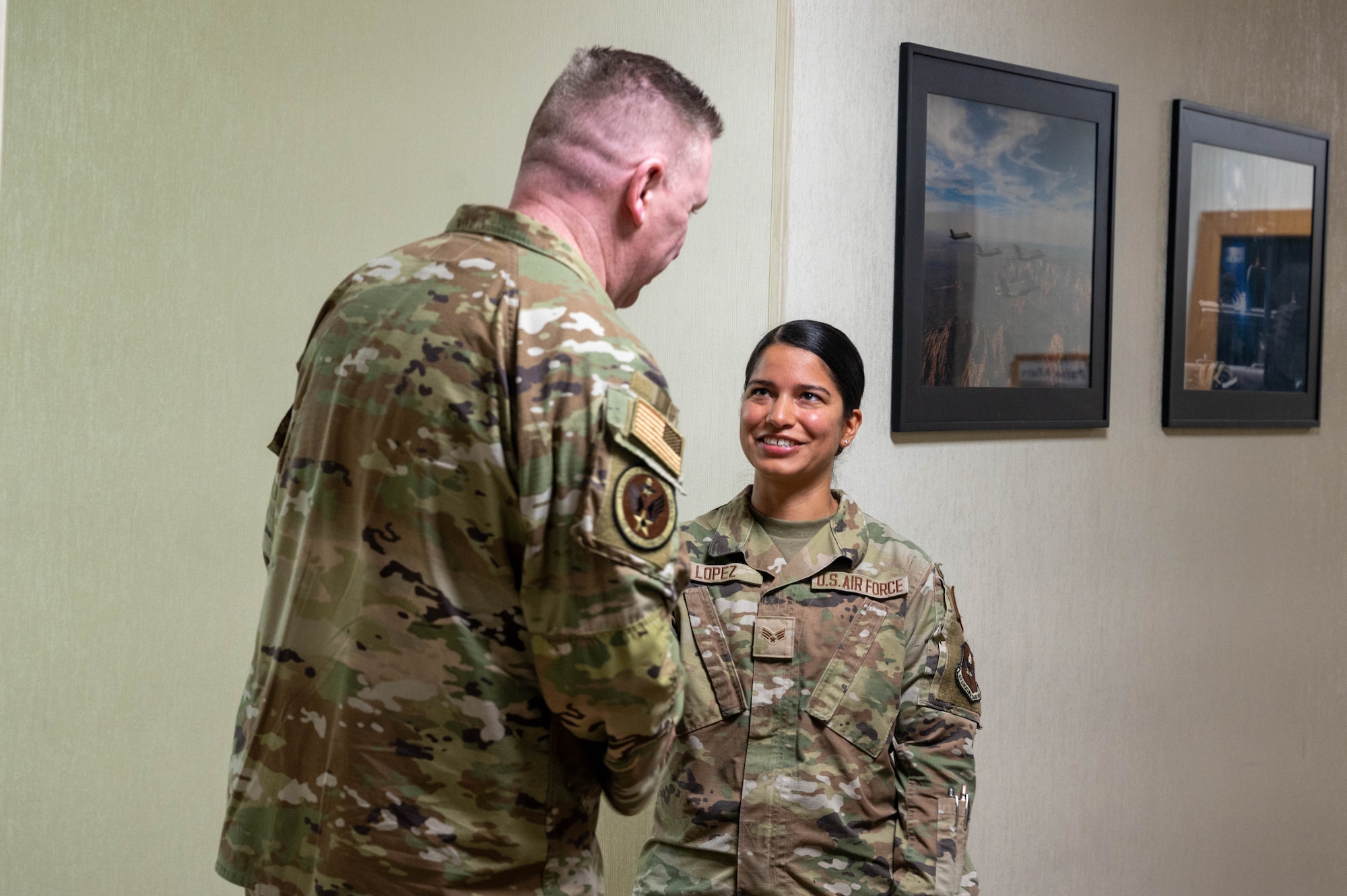 U.S. Air Force Chief Master Sgt. Chad Bickley, command chief of Air Education and Training Command, coins Senior Airman Alexis Lopez, 56th Fighter Wing religious affairs assistant, during a base visit, Aug. 18, 2023, at Luke Air Force Base, Arizona.