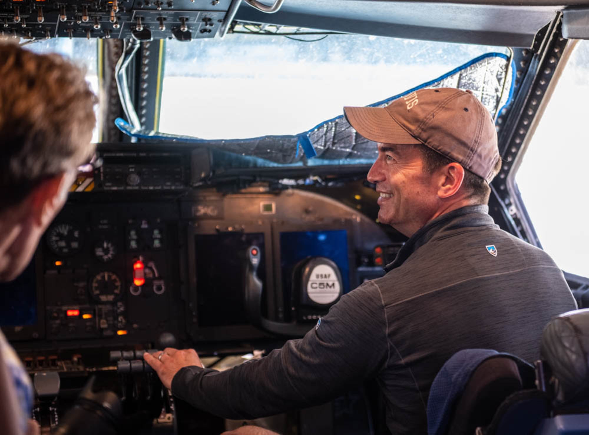 person sits in co pilot seat on plane