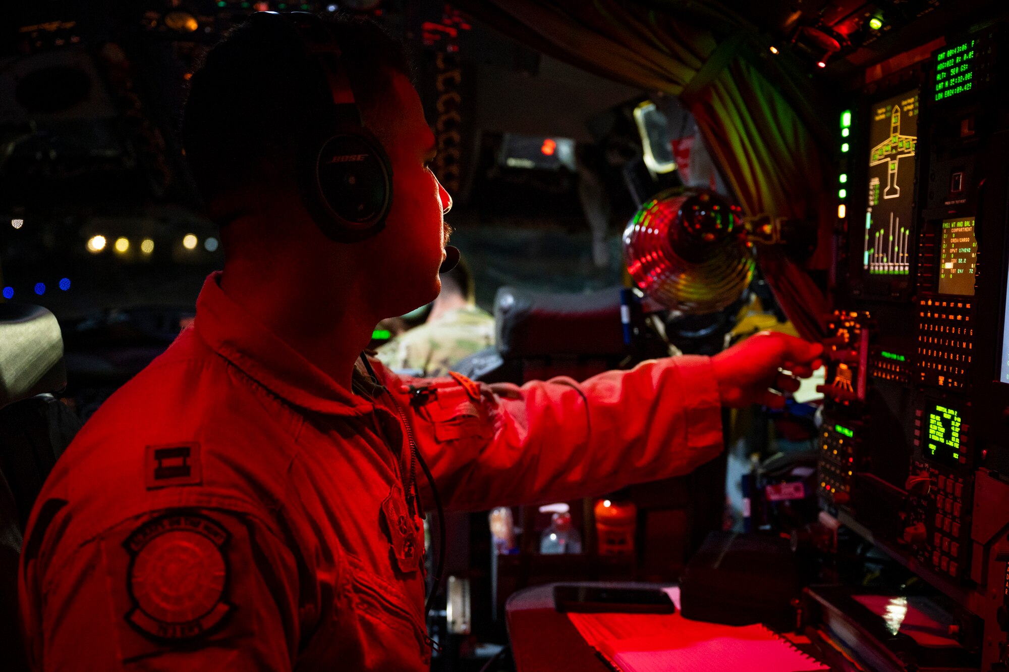 A service member pressing switches on an aircraft
