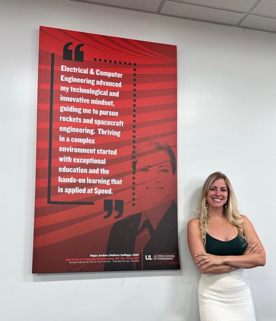 Woman poses for a photo in front of a sign