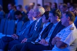 A group of people are seated in a conference center.