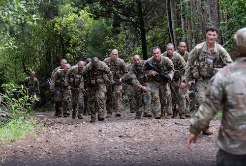 Ranger Assessment Course students run up the largest hill—known as Big Ivan—May 23, 2023, Schofield Barracks, Hawaii. During the course the Airmen, Soldiers and Guardian worked together, further reinforcing the need to understand what it’s like to work in a joint environment and in turn how to better support one another once they return to their respective units. (U.S. Air Force photo by Tech. Sgt. Hailey Haux)