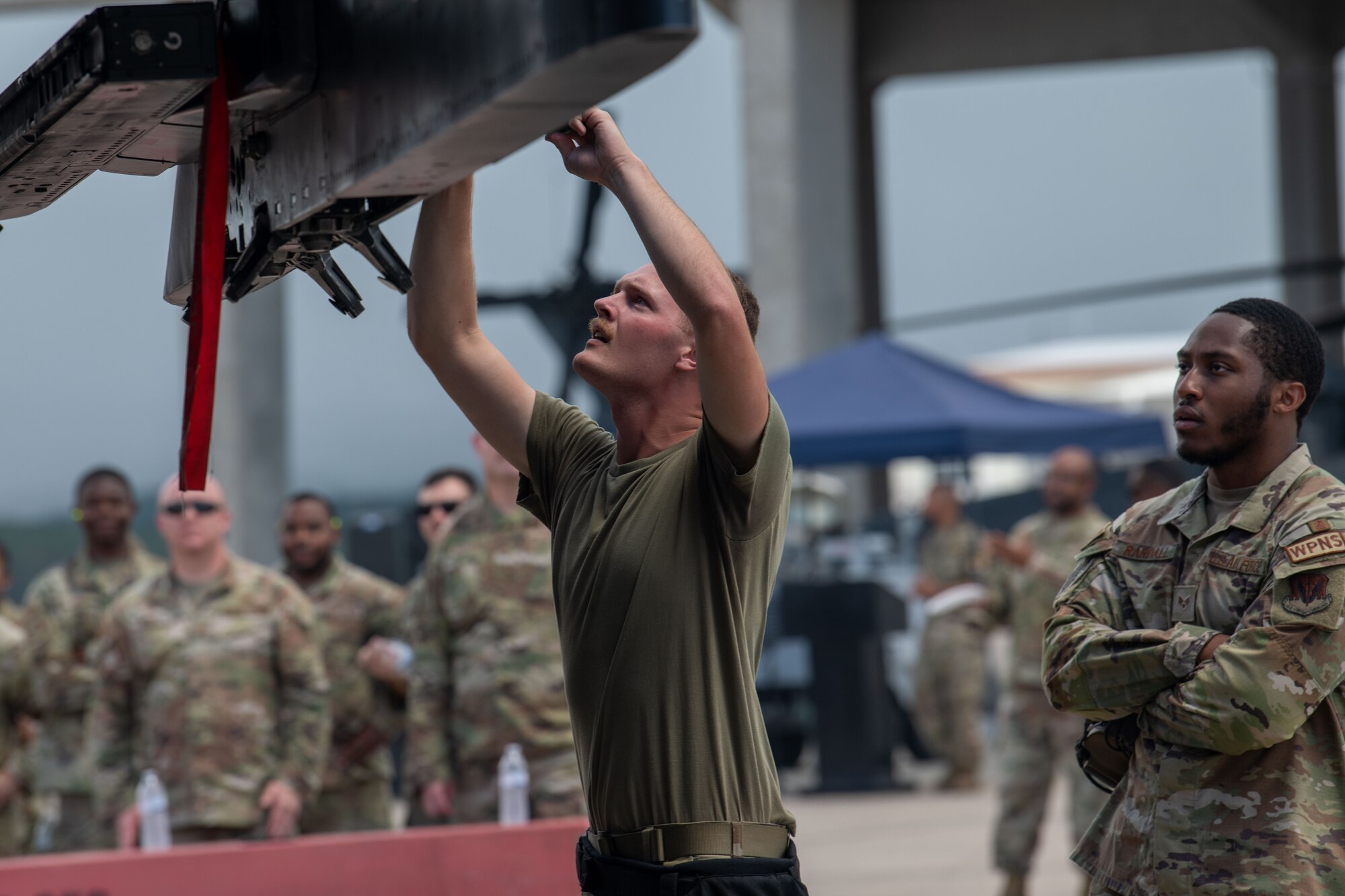 Crew member prepares to load munitions onto an F-15E Strike Eagle during a weapons load competition.