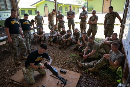Ranger Assessment Course students learn how to take apart and name the main components of different weapons systems, May 29, 2023, Schofield Barracks, Hawaii. Truly representing a joint force, there were service members from numerous Air and Space Force Specialty Codes and Army Military Occupational Specialties in the RAC. It ranged from Army infantry to Air Force medics and Space Force developmental engineer and included career fields like engineer officer, military police, contracting, security forces and others. (U.S. Air Force photo by Tech. Sgt. Hailey Haux)