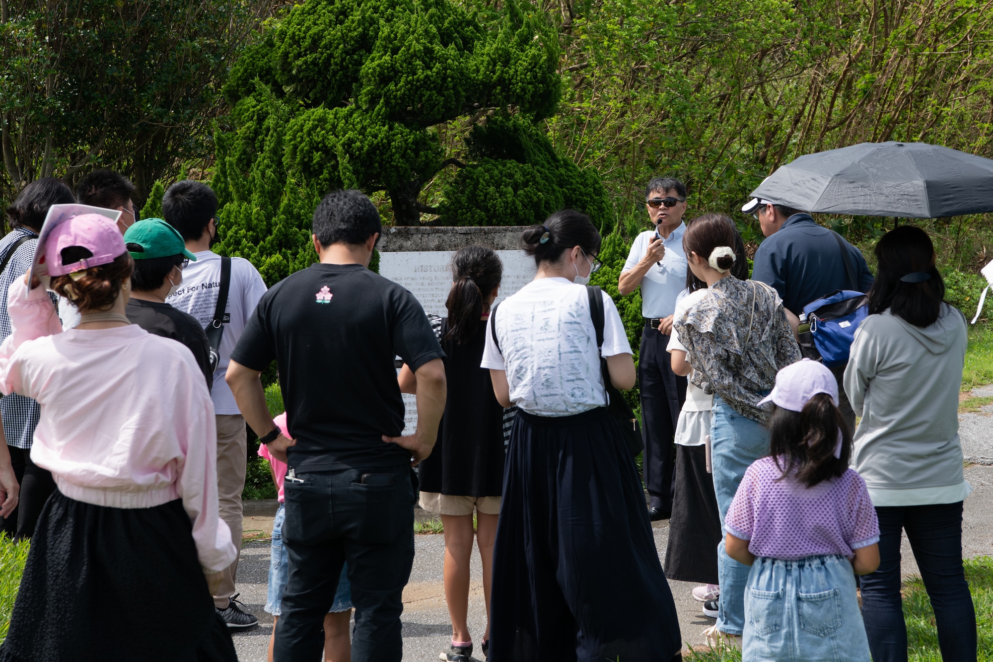 Okinawan residents gather around a tour guide.