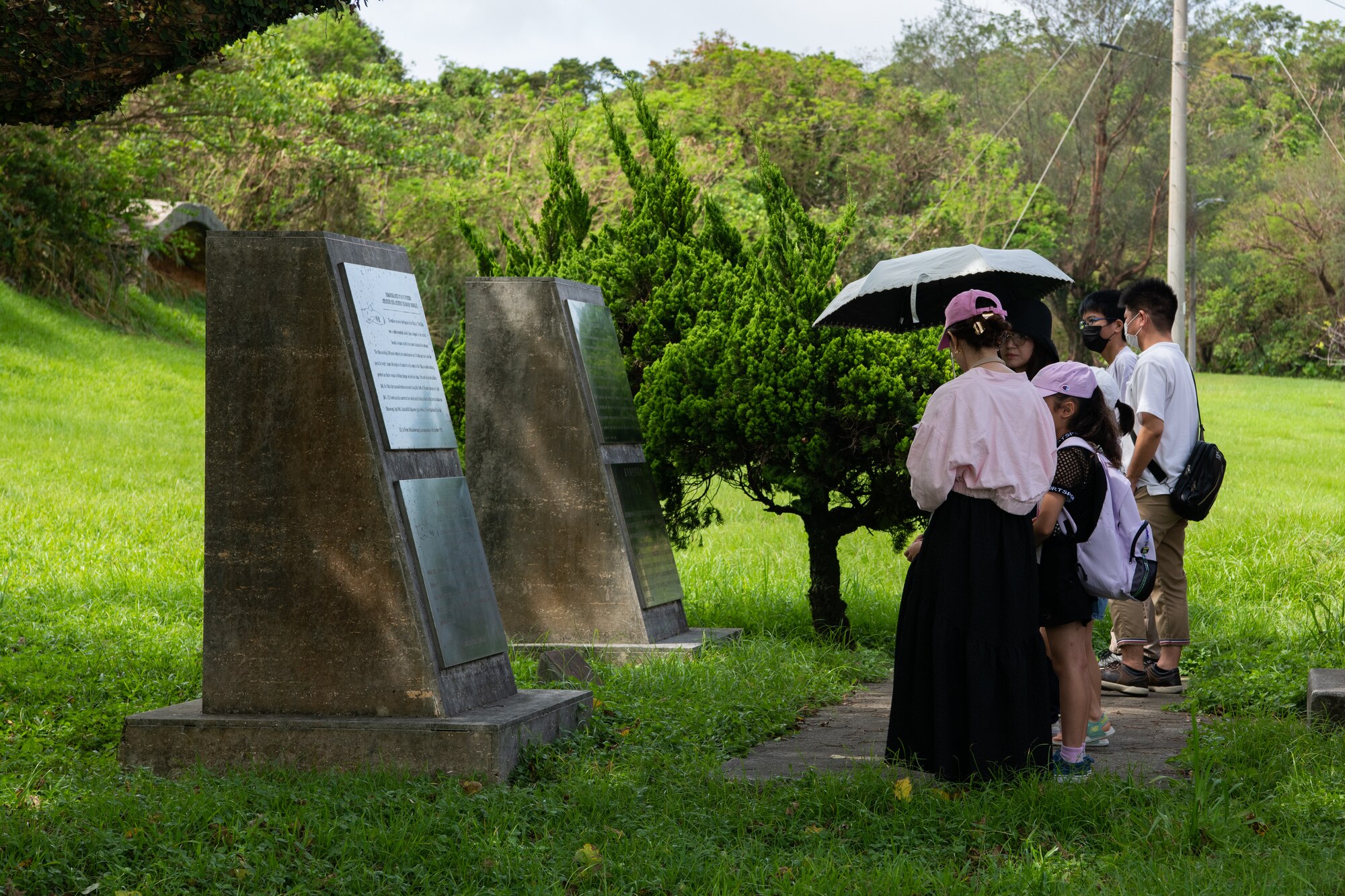 Okinawan residents read a plaque.