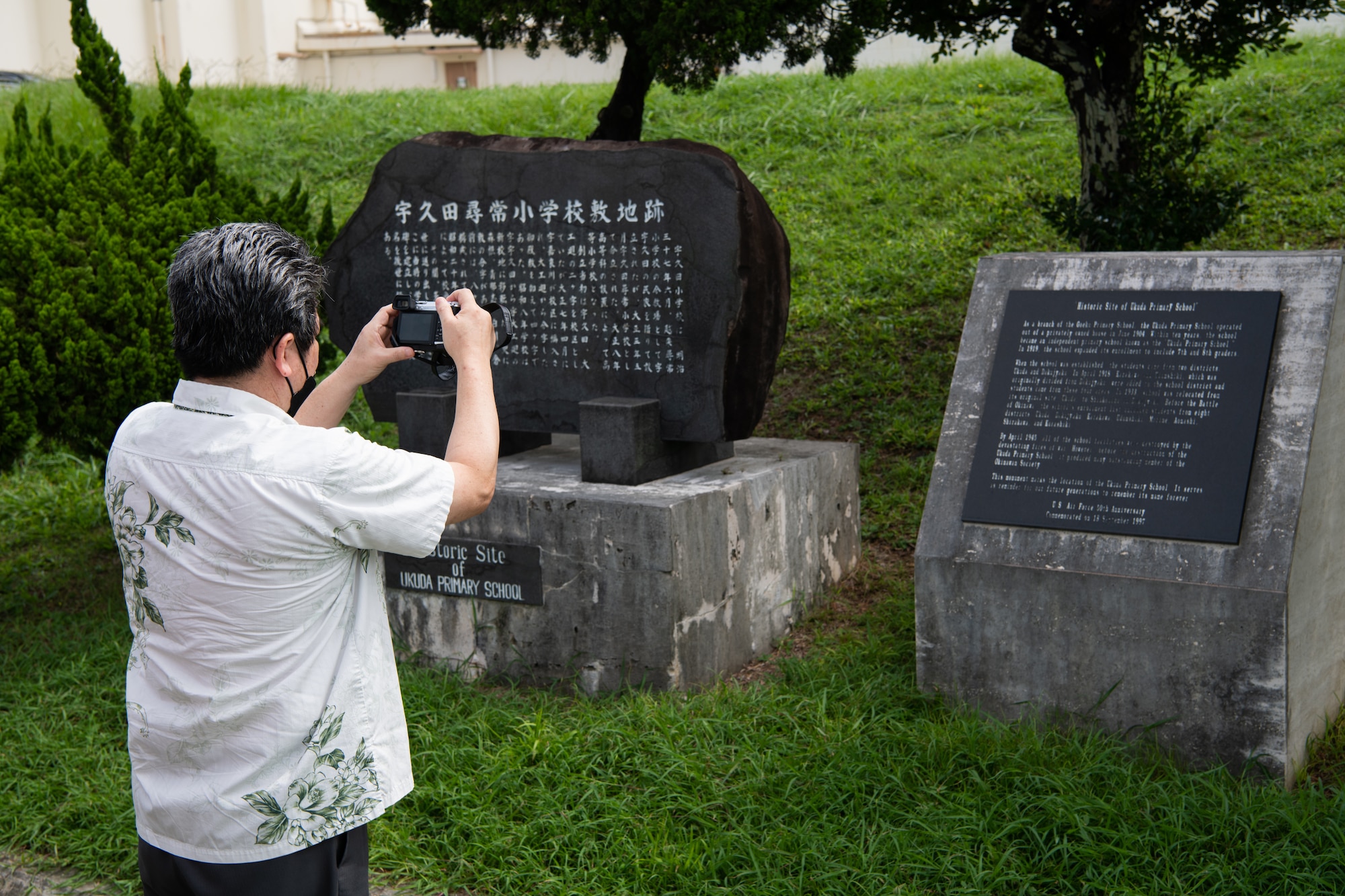 An Okinawan resident takes a picture of a plaque.