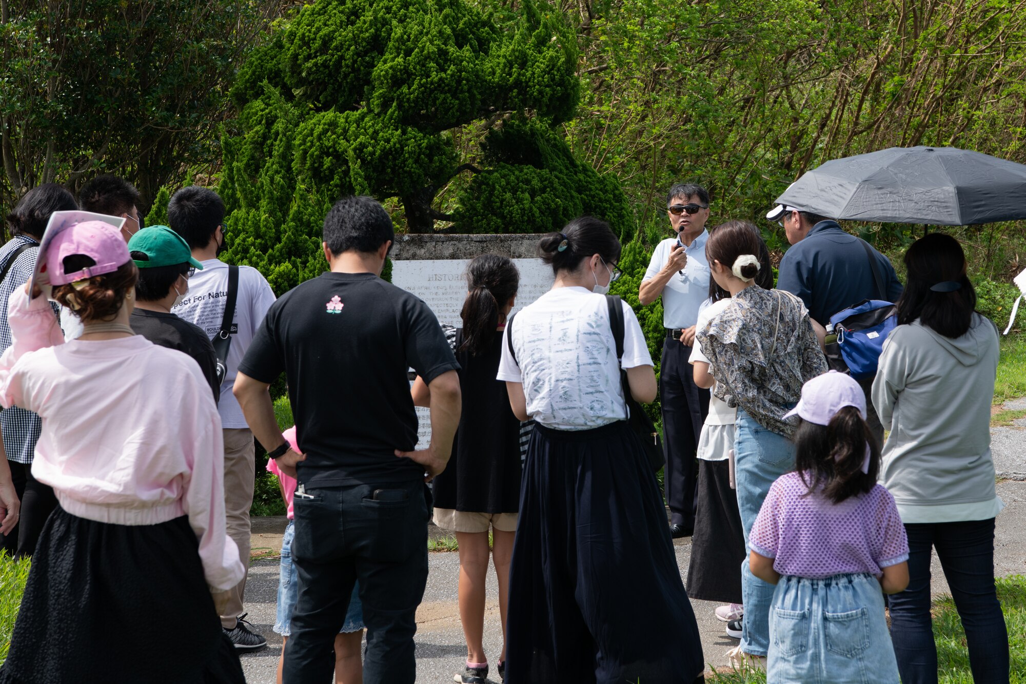Okinawan residents gather around a tour guide.