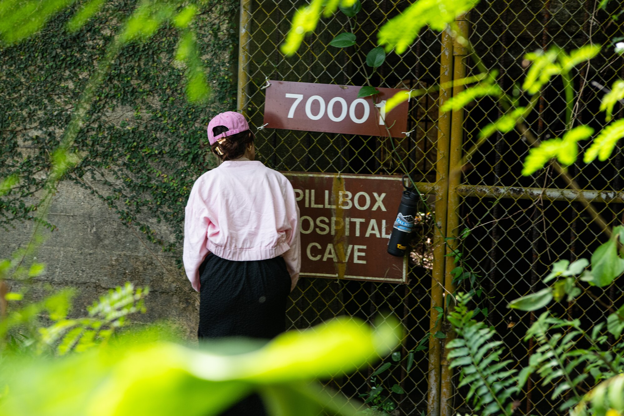 An Okinawan resident looks into an old hospital cave.