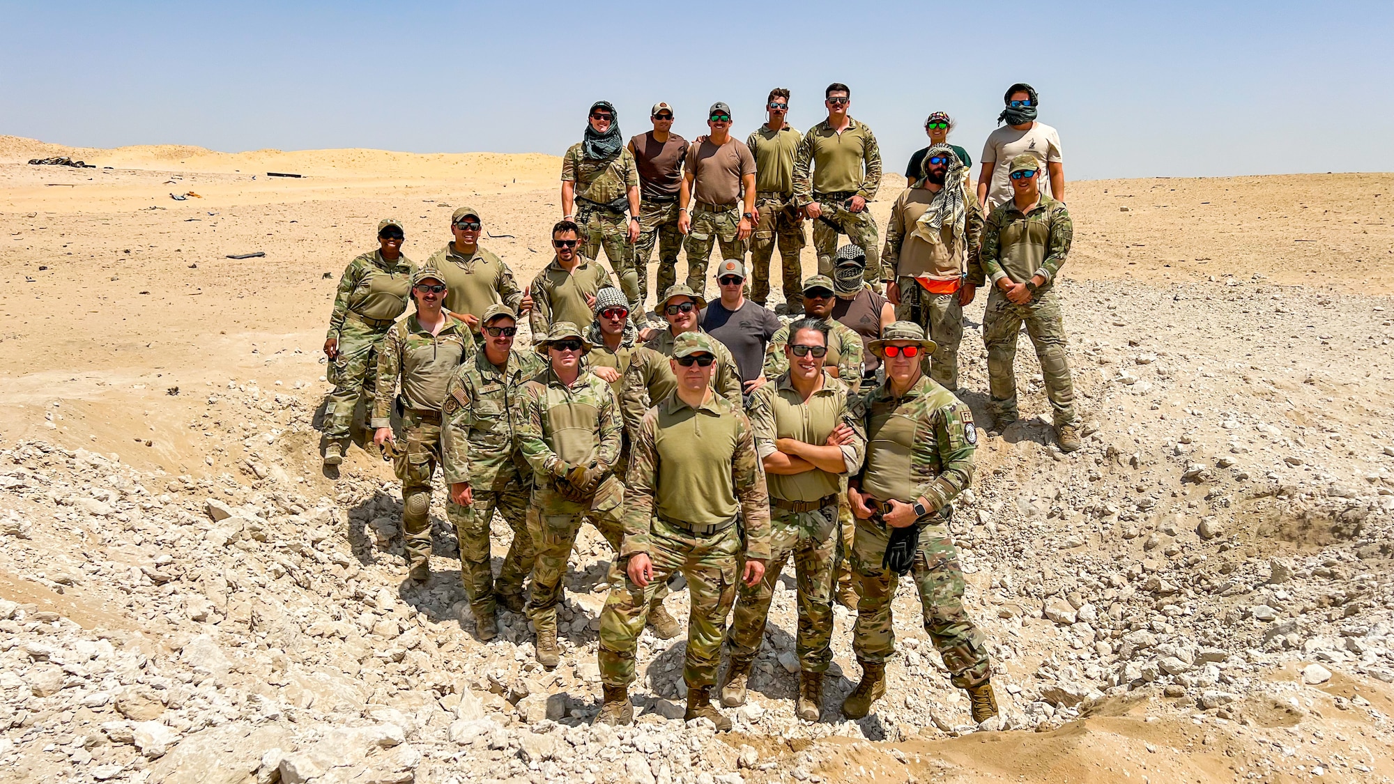 U.S. Army, U.S. Air Force, and U.S. Navy explosive ordnance disposal technicians from across Kuwait pose together after completing a large-scale detonation during Operation Solar Flare at Udairi Range, Kuwait, Aug. 24, 2023. Solar Flare is a 5-day, joint-service field training exercise developed and hosted by the 386th and 332nd Expeditionary Civil Engineer Squadron’s EOD teams that brought together 30 Army, Navy, and Air Force personnel for a series of intense training scenarios focused on working together through current and emerging threats in the CENTCOM AOR. (U.S. Air Force photo by Staff Sgt. Kevin Long)