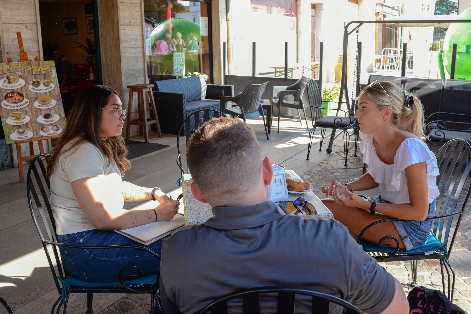 3 people sitting around a table outside