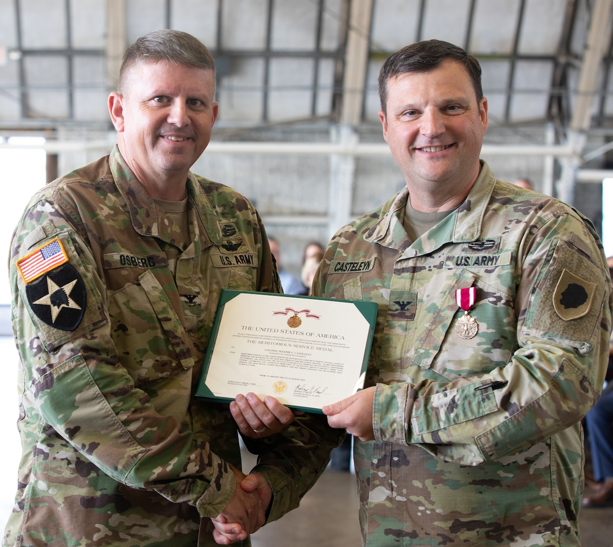 Illinois Army National Guard Col. Jason Osberg presents Col. Max Casteleyn with the Meritorious Service Medal during the change of command ceremony Aug. 27, 2023 in Peoria, Illinois, for commendable service as the commander of the 244th Digital Liaison Detachment, spanning from Jan. 10, 2022 to Aug. 27, 2023.