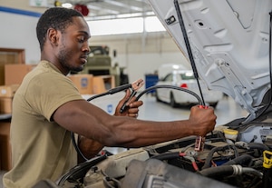 a person charges a vehicle battery