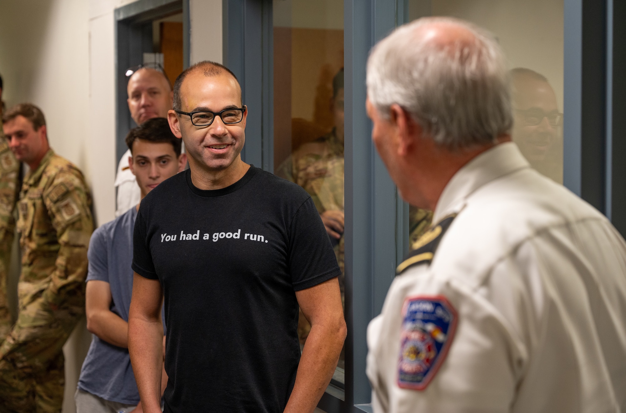 James Murray stands in a hallway listening to Peterson Space Force Base firefighters.