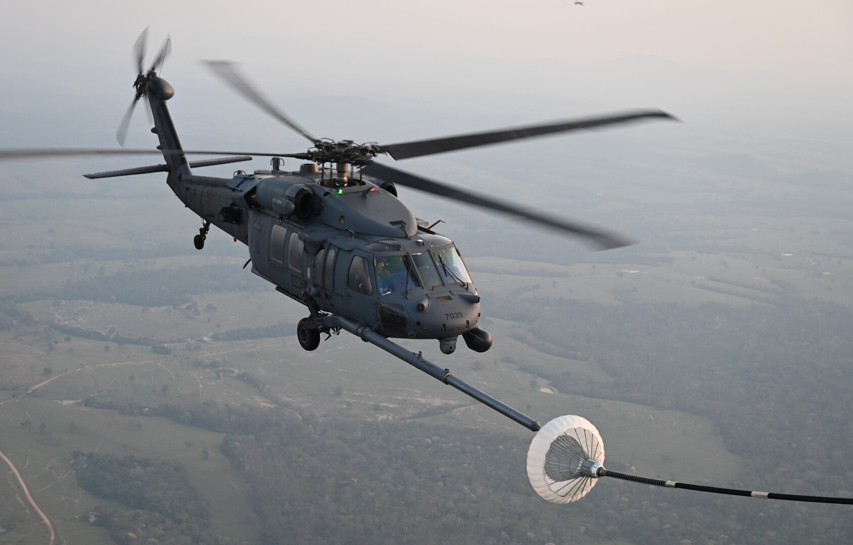 An HH-60G Pave Hawk rescue helicopter flown by Airmen from the New York Air National  Guard’s 106th Rescue Wing refuels from the wing’s C-130J Combat King II search and rescue aircraft during a search and rescue training mission over Campo Grande, Brazil, Aug. 23, 2023.