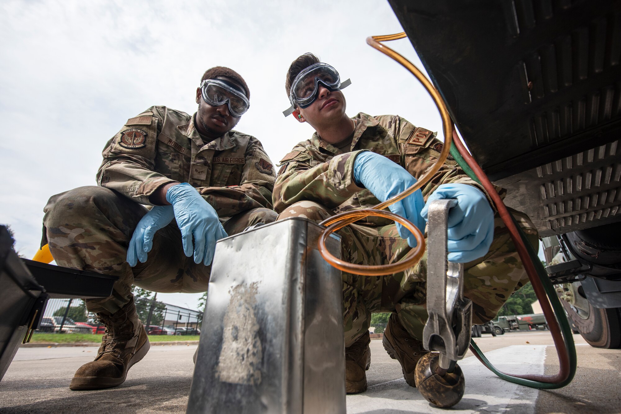 Staff Sgt. Dylan Gardner, right, 4th Logistics Readiness Squadron fuels laboratory NCOIC, and Airman 1st Class Adrian Morris, 4th LRS fuels laboratory fuels distribution operator, transfer fuel from fuel truck to a container in preparation for testing at Seymour Johnson Air Force Base, North Carolina, Aug. 10, 2023. Airmen assigned to the 4th LRS fuels lab are responsible for testing the cleanliness and quality of fuel used in ground and air operations to help ensure the safety of Airmen and assets when performing the day-to-day mission. (U.S. Air Force photo by Tech. Sgt. Christopher Hubenthal)