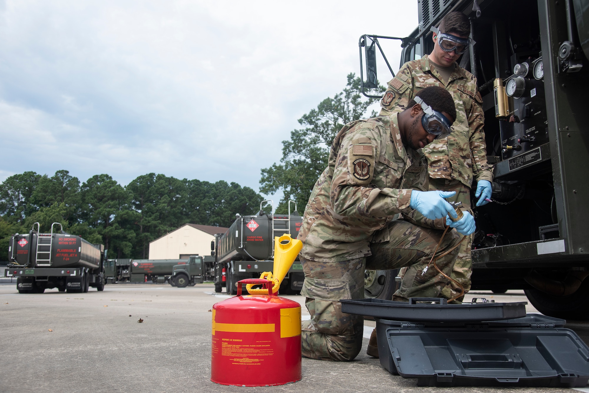Staff Sgt. Dylan Gardner, background, 4th Logistics Readiness Squadron fuels laboratory NCOIC, and Airman 1st Class Adrian Morris, 4th LRS fuels laboratory fuels distribution operator, transfer fuel from fuel truck to a container in preparation for testing at Seymour Johnson Air Force Base, North Carolina, Aug. 10, 2023. Airmen assigned to the 4th LRS fuels lab are responsible for testing the cleanliness and quality of fuel used in ground and air operations to help ensure the safety of Airmen and assets when performing the day-to-day mission. (U.S. Air Force photo by Tech. Sgt. Christopher Hubenthal)