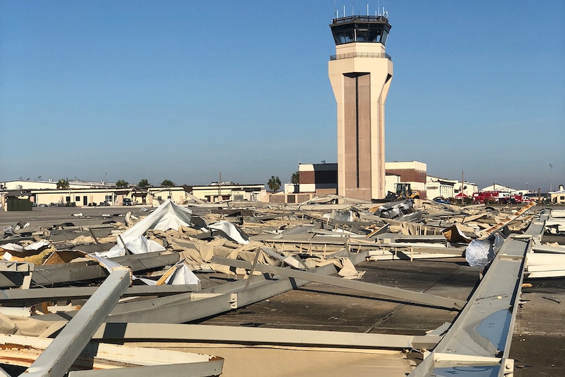 Building debris scattered across the tarmac is a sharp contrast to the intact and erect air traffic control tower.