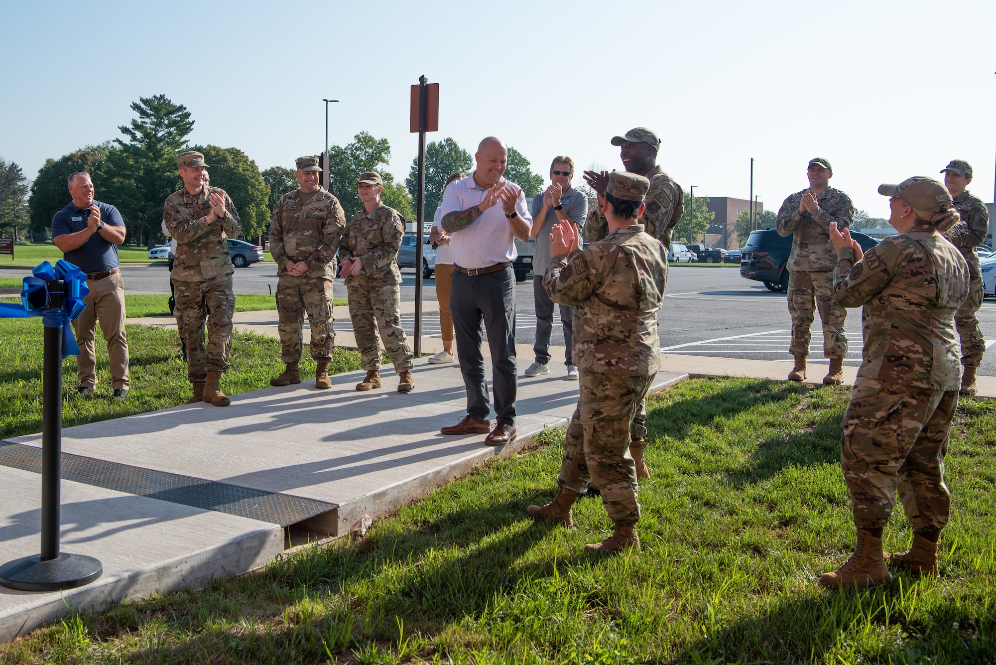 A group of people clap during a ribbon cutting ceremony.