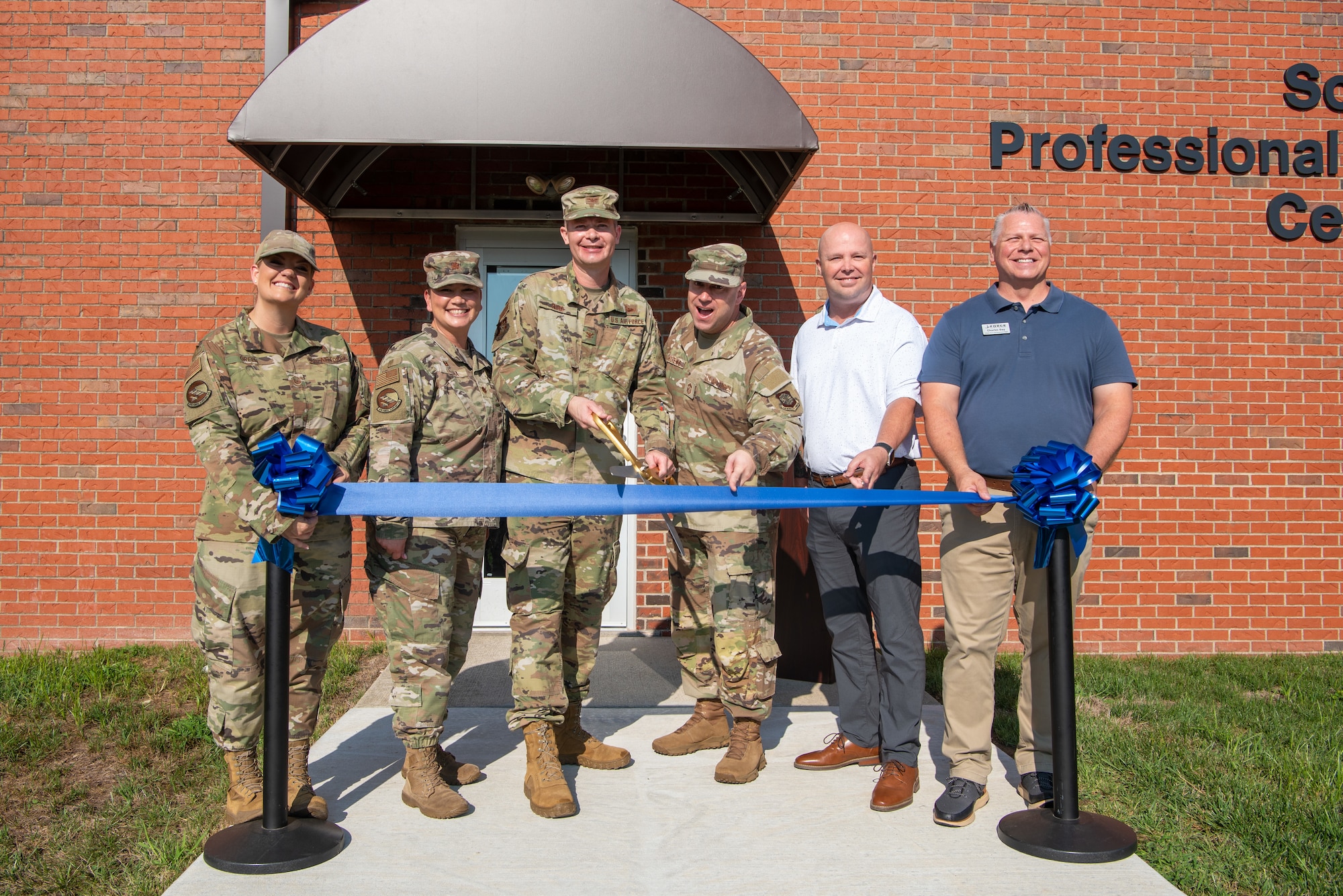 Group cuts ribbon for opening ceremony.