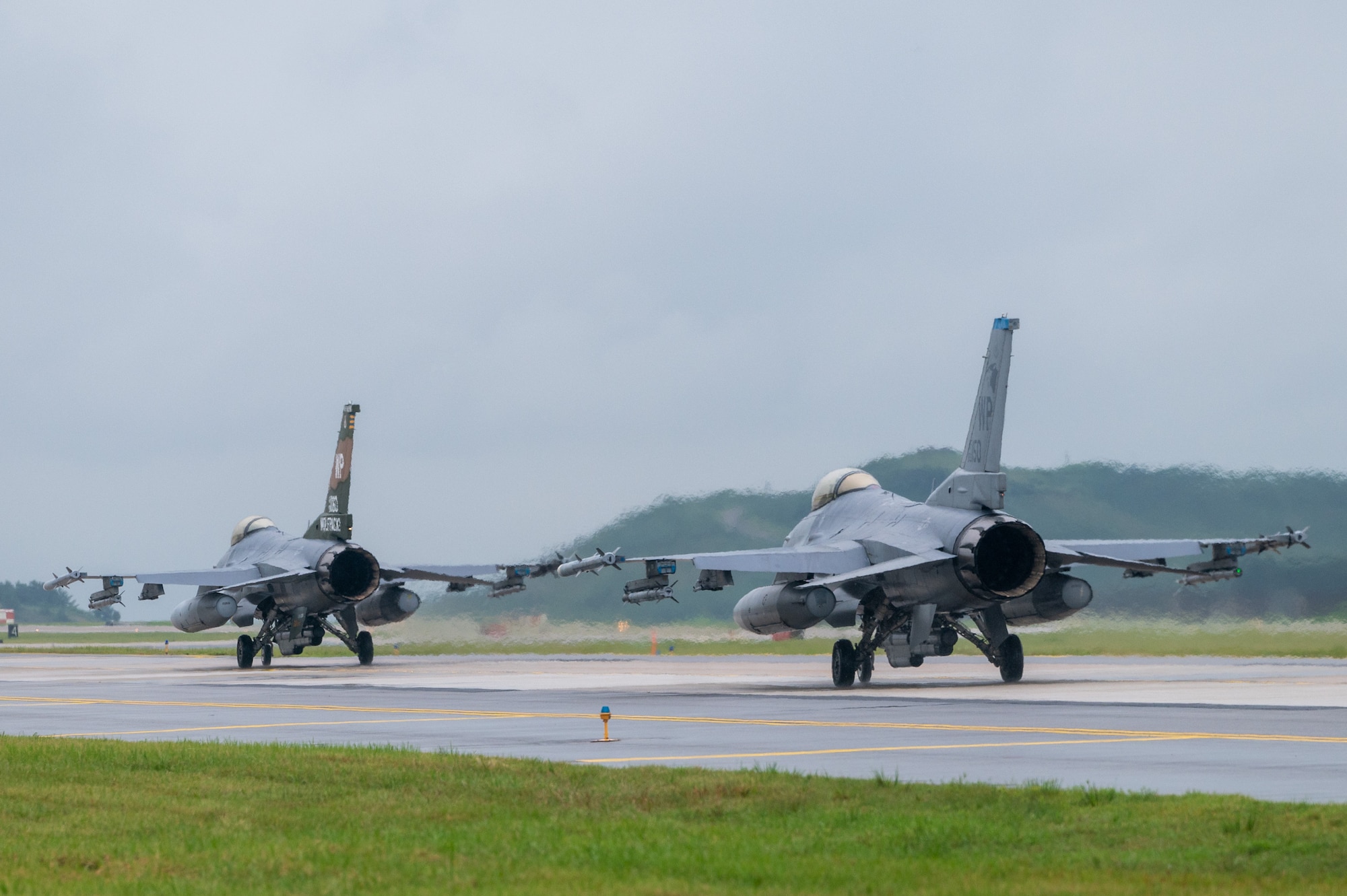 Two U.S. Air Force F-16 Fighting Falcons assigned to the 35th Fighter Squadron taxi on the runway.