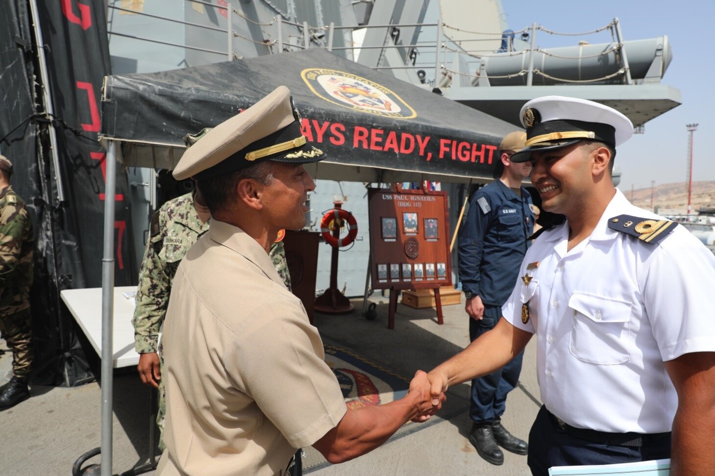 Cmdr. Corry Lougee, commanding officer of the Arleigh Burke-class guided-missile destroyer USS Paul Ignatius (DDG 117), welcomes aboard an officer from the Royal Moroccan Sigma-class corvette frigate RMNS Sultan Moulay Ismail (614), onboard in preparation for exercise Atlas Handshake 2023, Aug. 25, 2023. Paul Ignatius is on a scheduled deployment in the U.S. Naval Forces Europe area of operations, employed by the U.S. Sixth Fleet to defend U.S., allied and partner interests. (U.S. Navy photo by Mass Communication Specialist 1st Class Zac Shea)