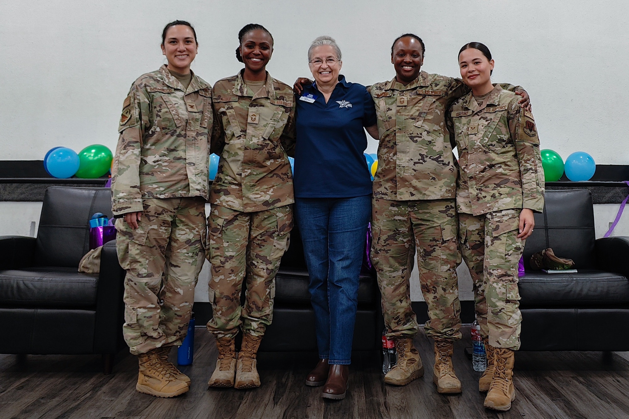 A group photo of four Airmen and a civilian